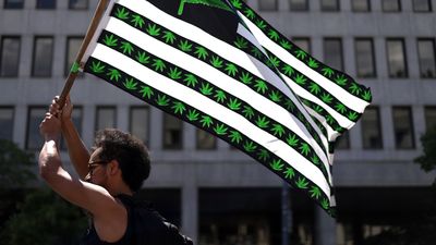 A cannabis activist holds a flag during a march on Independence Day on July 4, 2021 in Washington, DC.