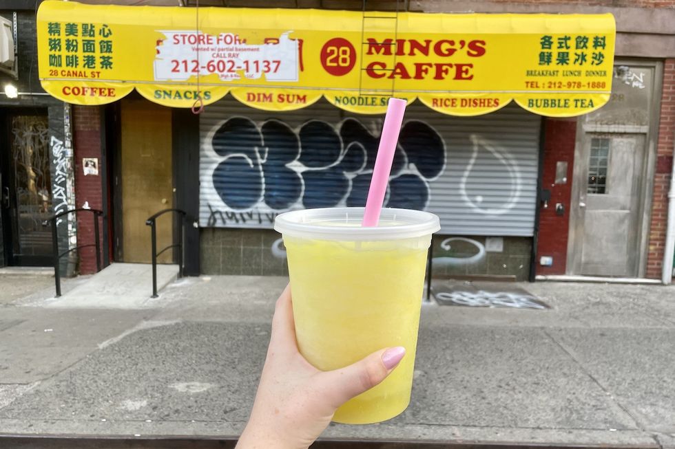 A fruit smoothy in front of a storefront.