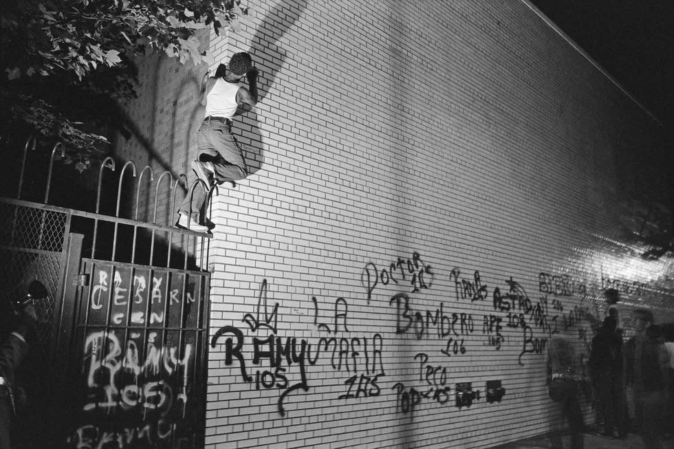 A group of teenage boys tagging the newly cleaned wall of the West Side Hospital with spray paint, New York, US, 1972. 