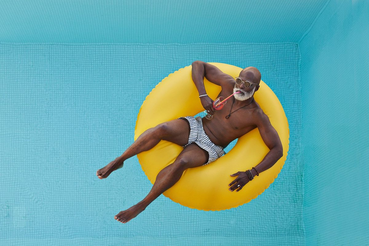 Bald man relaxing in yellow inflatable ring, following our self care tips.