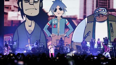 Damon Albarn on stage in front of animated band Gorillaz