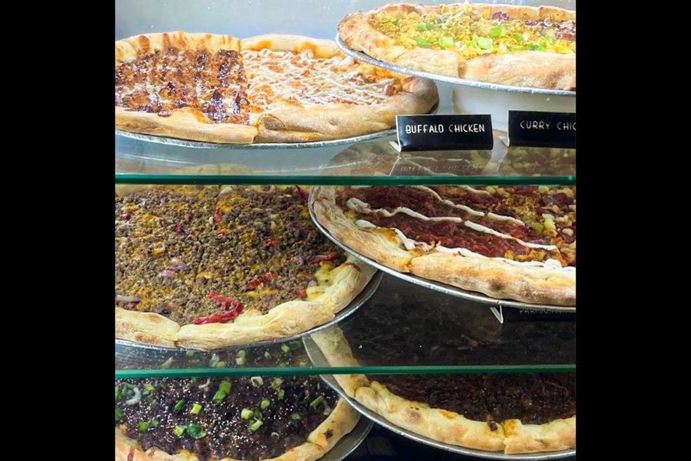 Different styles of pizza in a shelf