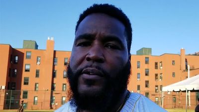 Dr. Umar Johnson in front of a building