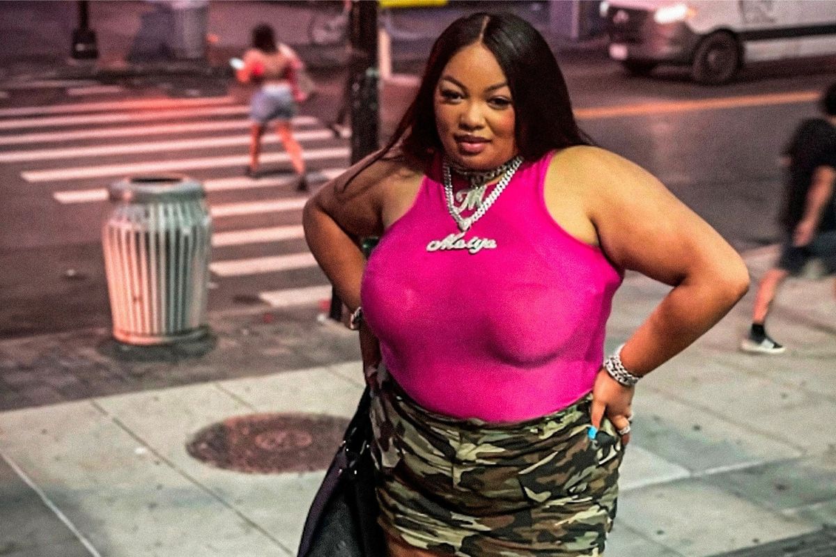 Female rapper Maiya The Don wearing a pink shirt standing outside.