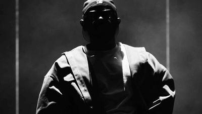 Kendrick Lamar wearing backwards hat during a show.