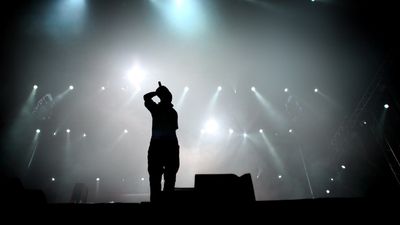 Silhouette of hip hop singer on stage.
