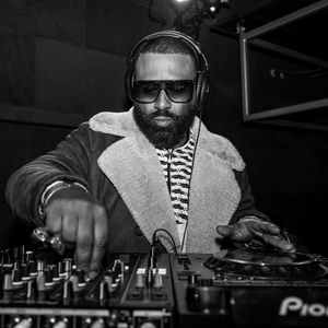 Madlib has his hands on a DJ deck. 