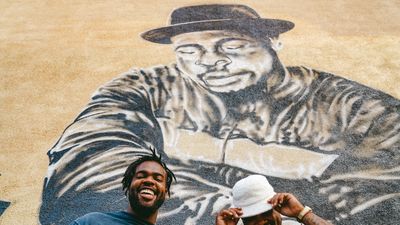 Jam Master Jays owners in front of jam master jay mural