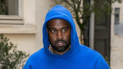 Kanye is seen walking in Paris in a royal blue hoodie in March of 2020.