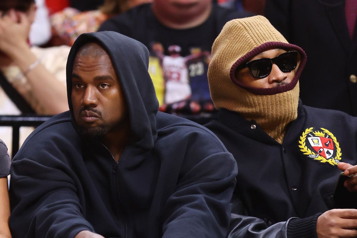 Kanye West (L) and Future look on courtside during the first half between the Miami Heat and the Minnesota Timberwolves at FTX Arena on March 12, 2022.