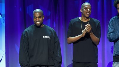 Kanye West and JAY-Z wearing all black, standing next to each other at the 2015 TIDAL launch event