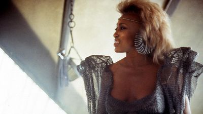 Tina Turner wearing silver attire in a scene from the film 'Mad Max Beyond Thunderdome,' 1985.