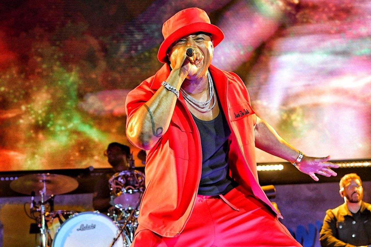 LL COOL J wearing red hat and suit.