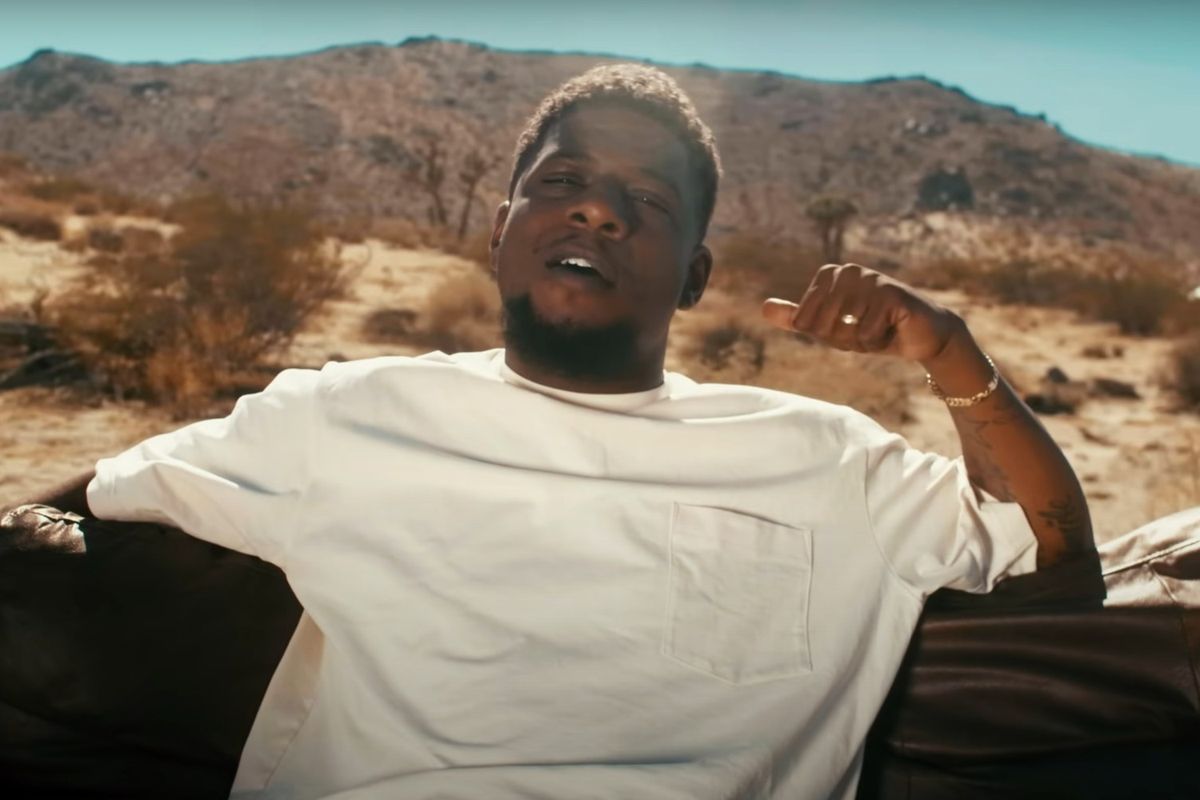 Mick Jenkins lounging in the desert in the video for "Contacts"