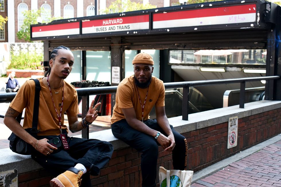 No Label Academy students Okay Cozy (left) and Justin Lindberg (right) take a rest in Harvard Square during a tour of the Harvard campus on August 20, 2023.