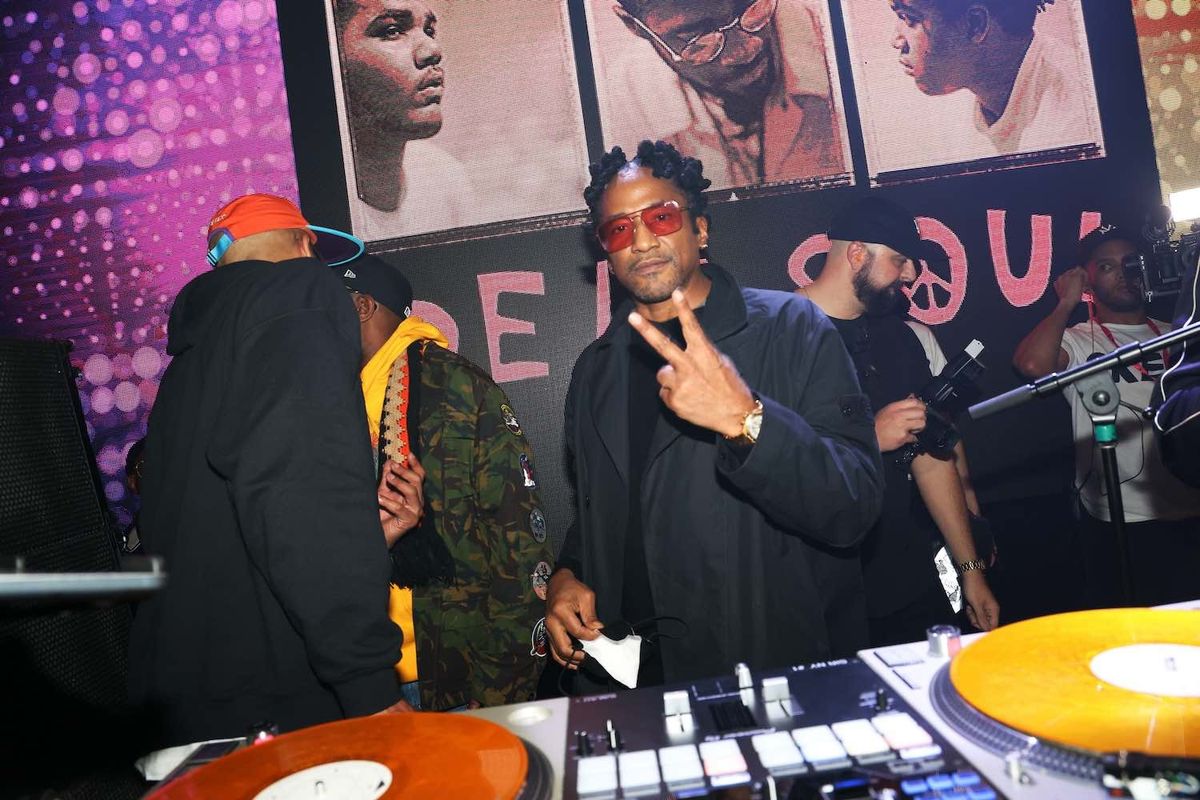 Q-Tip wearing red glasses at a party 