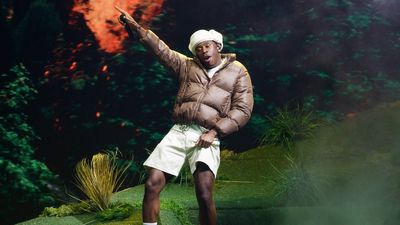 tyler, the creator performing with hat and brown coat