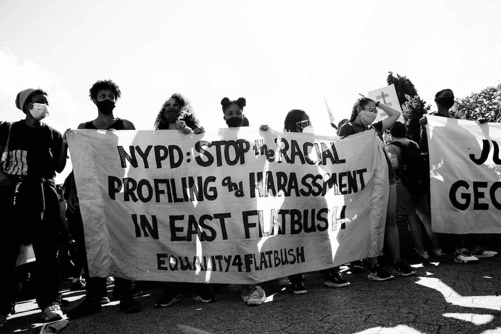 Protesters holding up sign against police in Brooklyn.