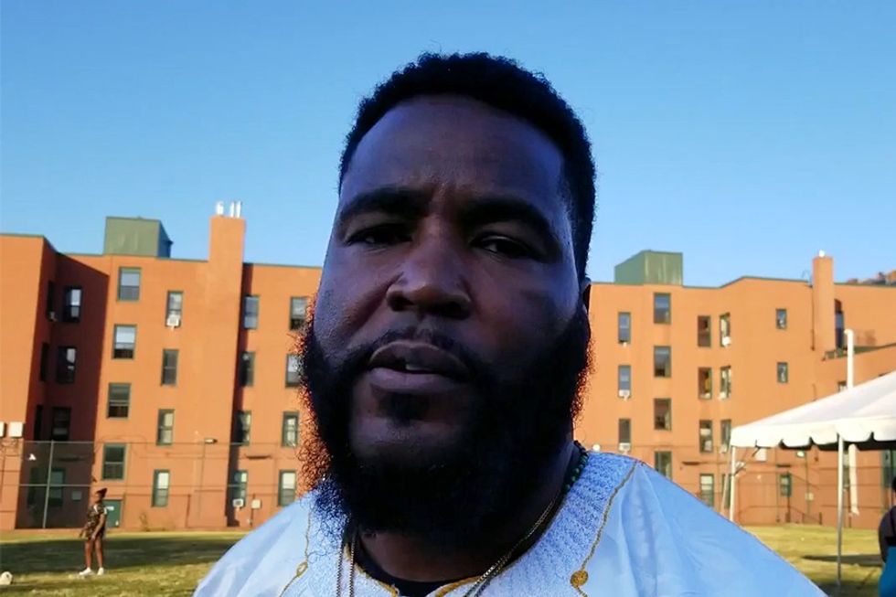 Dr. Umar Johnson in front of a building