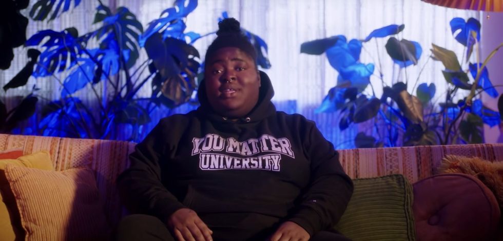 Alabama rapper Chika in a You Matter University hoodie sweatshirt in front of monsteras.