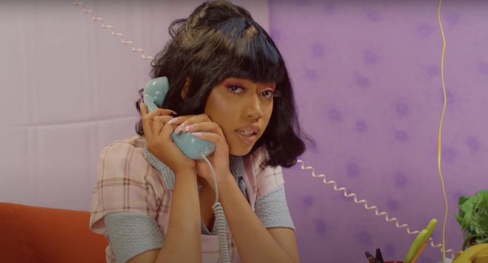 female Chicago rapper in tartan shirt on the phone