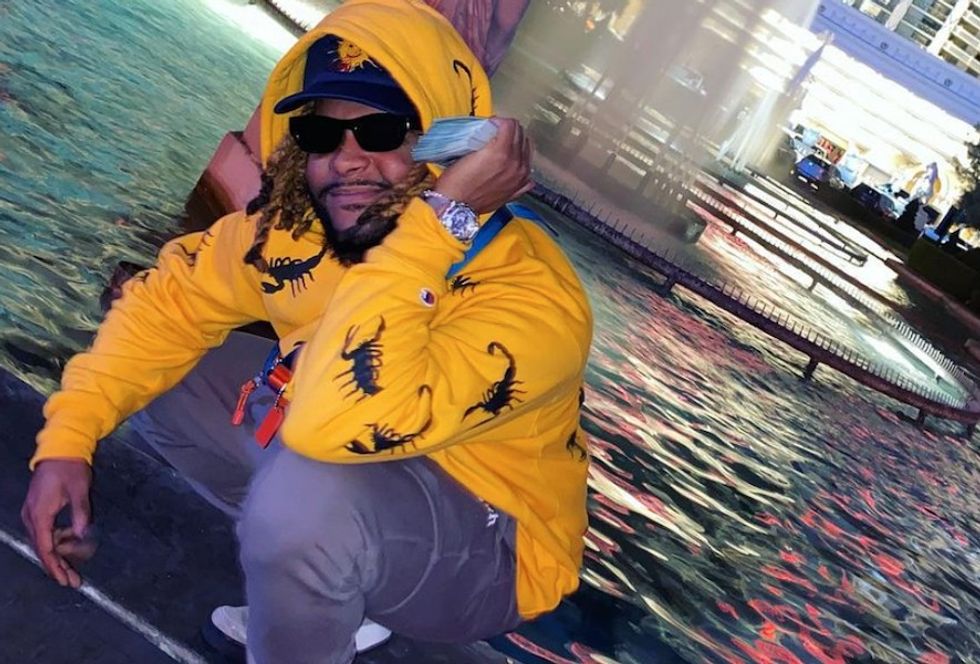 Buffalo producer Camoflauge Monk in a fountain on his money phone. 