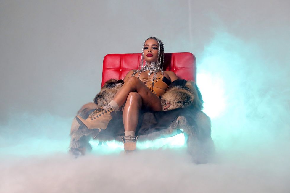 Dream Doll rapper sitting on red couch