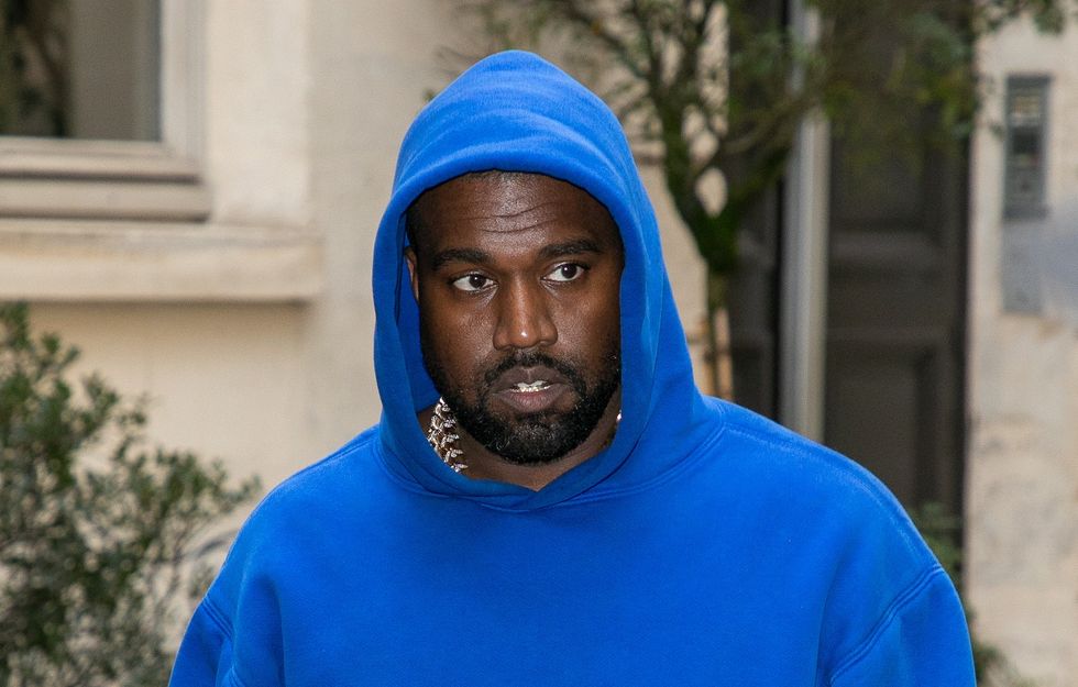 Kanye is seen walking in Paris in a royal blue hoodie in March of 2020.