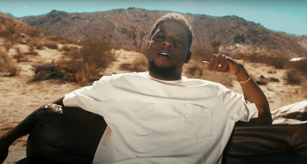 Mick Jenkins lounging in the desert in the video for "Contacts"