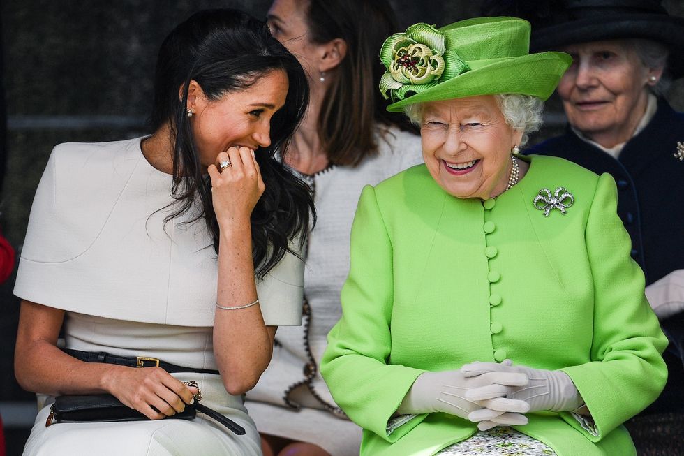 Queen Elizabeth II sitts and laughs with Meghan, Duchess of Sussex during a ceremony to open the new Mersey Gateway Bridge on June 14, 2018.